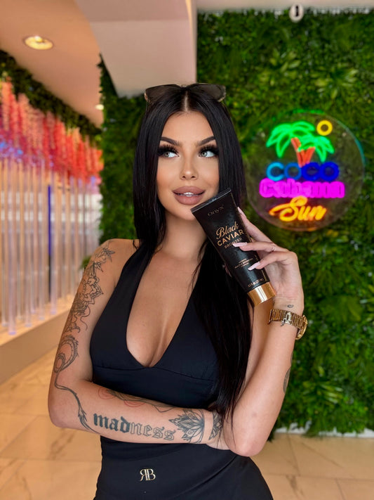 Woman holding Onyx Black Caviar with a neon sign in the background