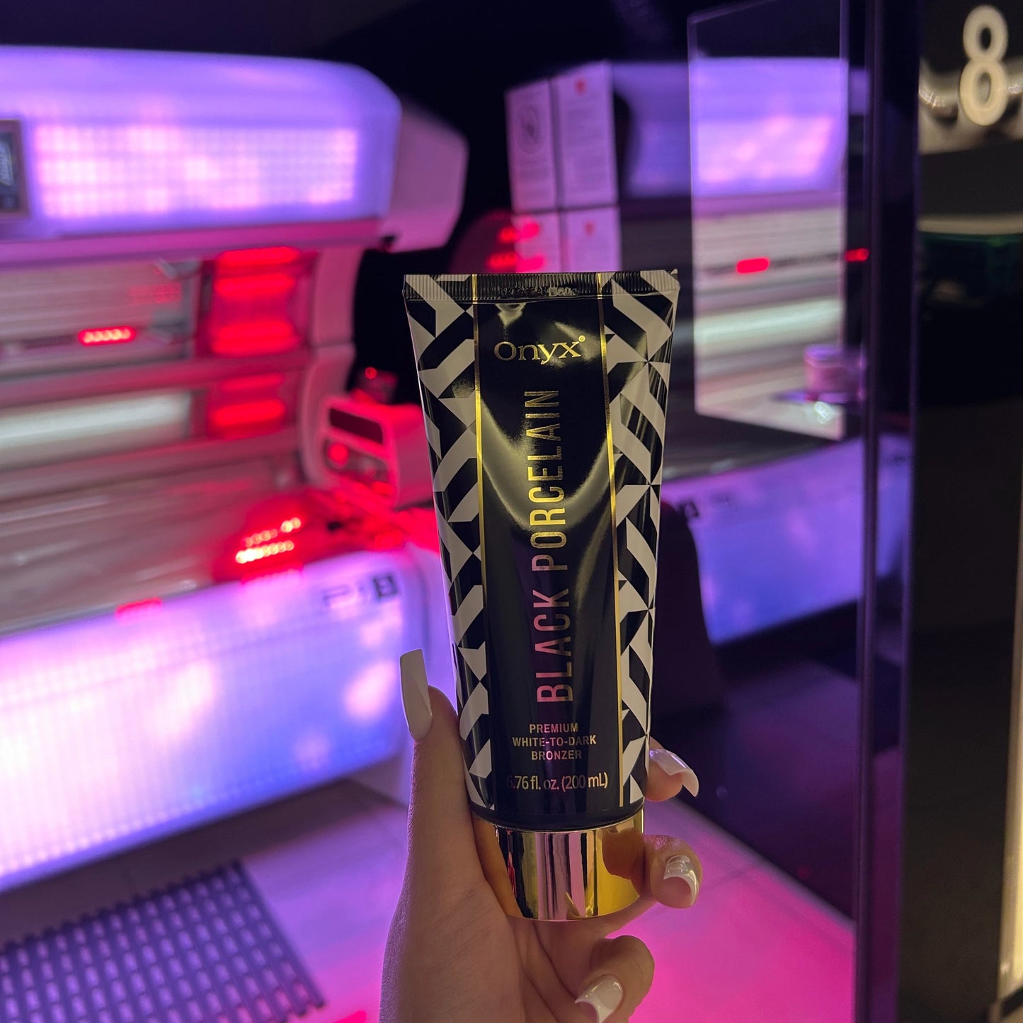 Onyx Black Porcelain White-to-Dark Bronzer placed in front of an illuminated sunbed, emphasizing its use for indoor tanning sessions.