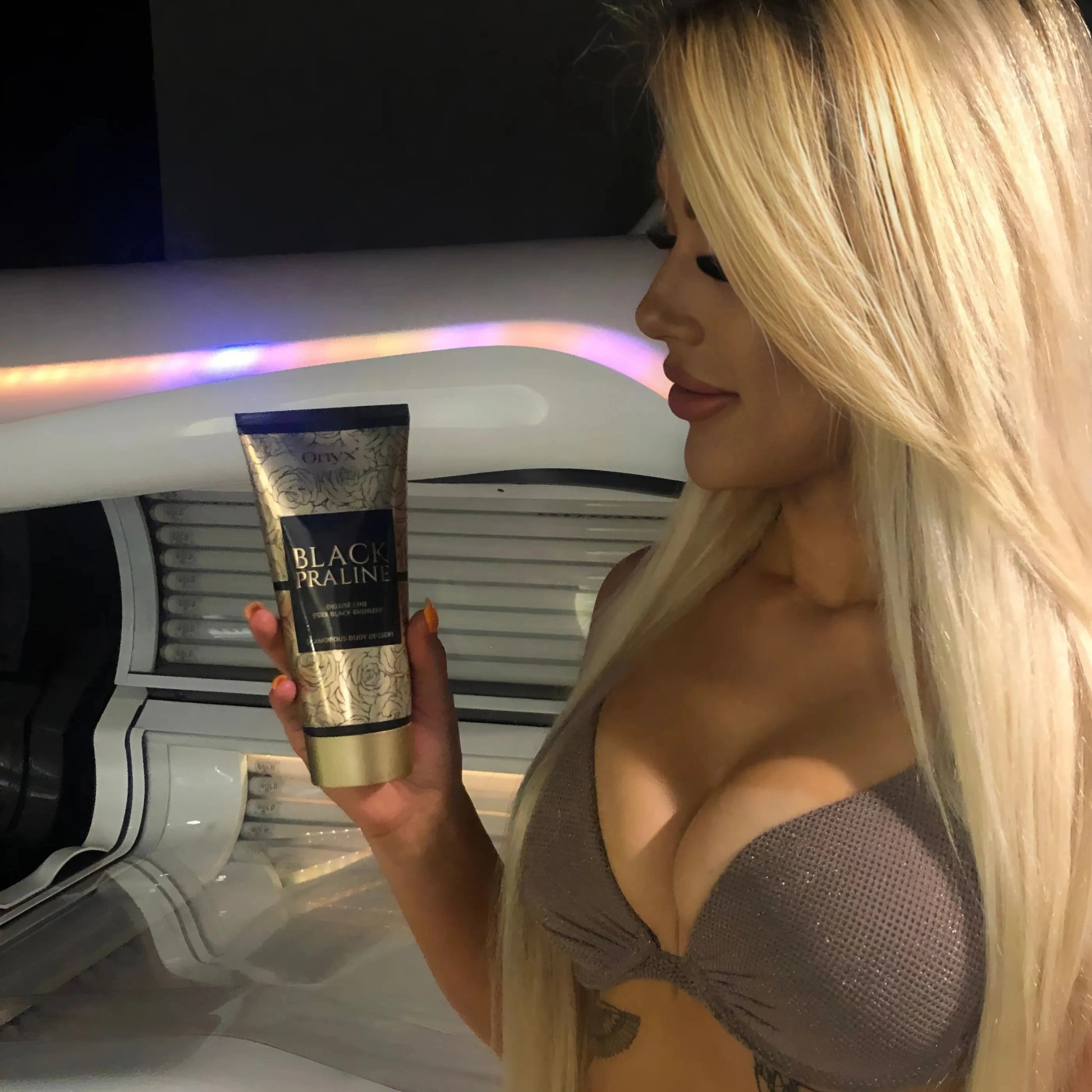 Onyx Black Praline Bronzer Lotion inside a sunbed, highlighting its tanning intensifier formula.