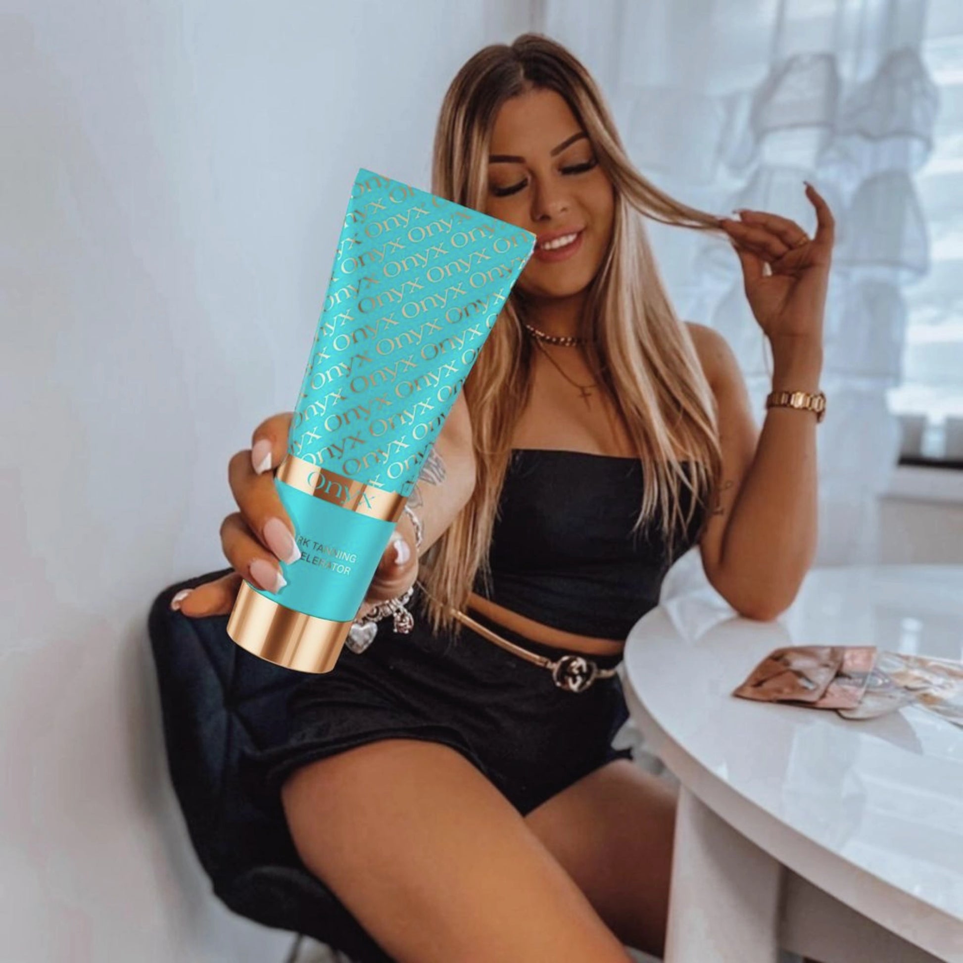 A person holding Onyx Dark Tanning Accelerator lotion, showcasing bronzed skin and smooth hydration.