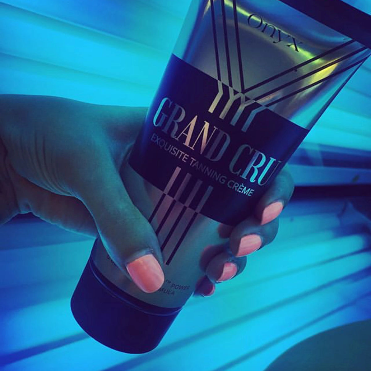 Close-up of Onyx Grand Cru tanning lotion in a UV tanning booth, boosting tan acceleration.