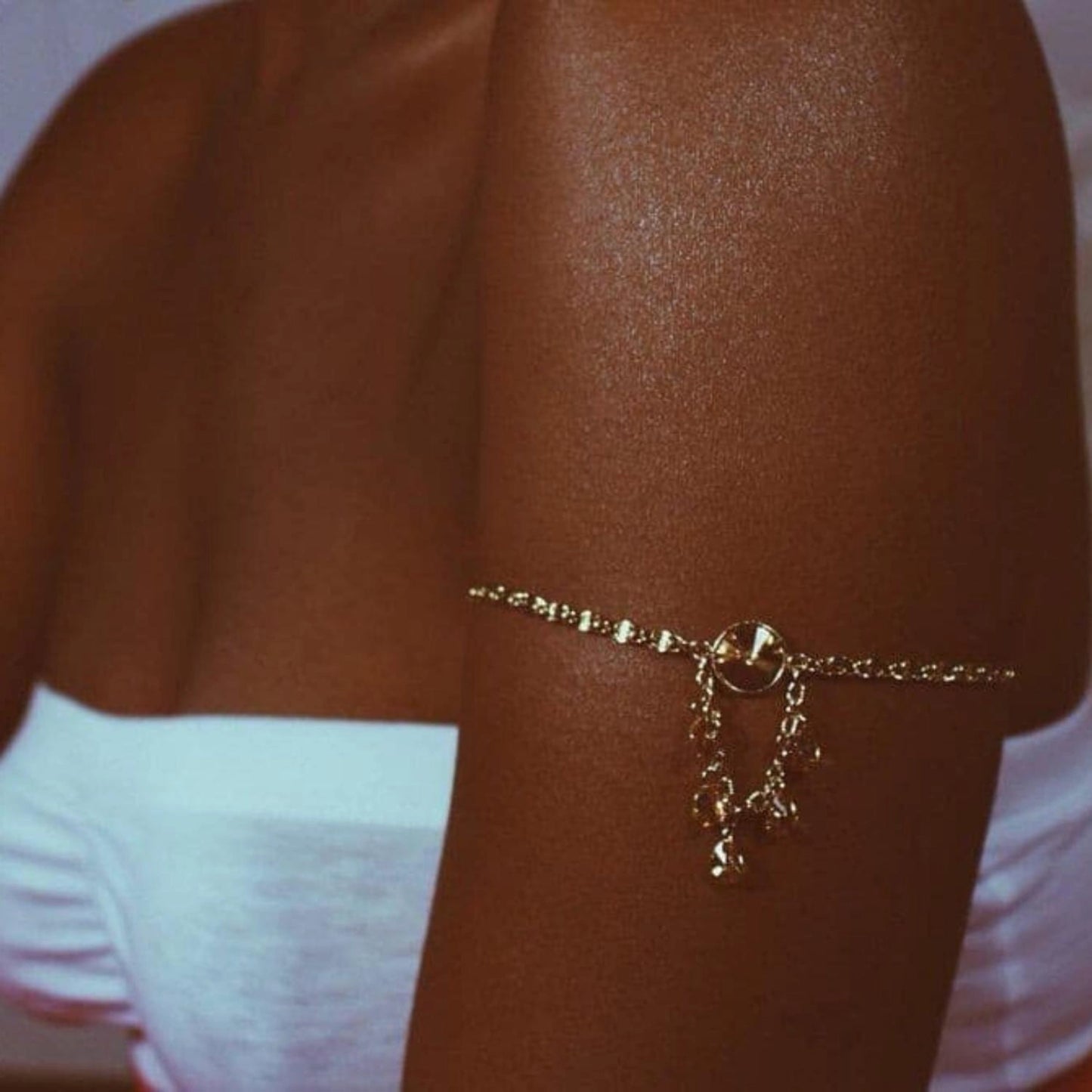 Woman's arm glistening with Onyx La Playa after-sun lotion, showing a soft, golden sheen.