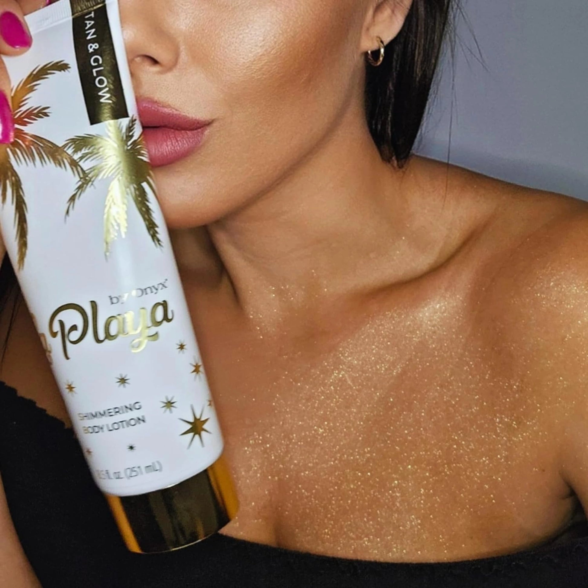 Woman applying Onyx La Playa shimmering lotion, revealing a golden glow on her décolletage.