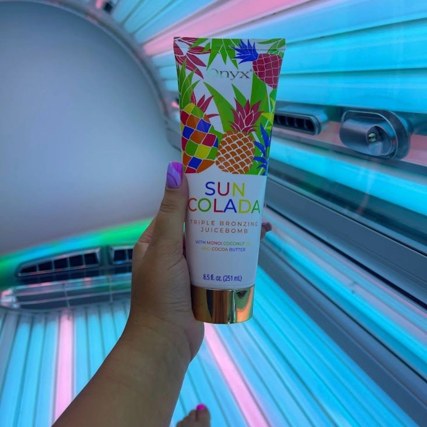 Onyx SunColada tanning lotion held before a UV tanning session, boosting melanin for an ultra-dark tan.