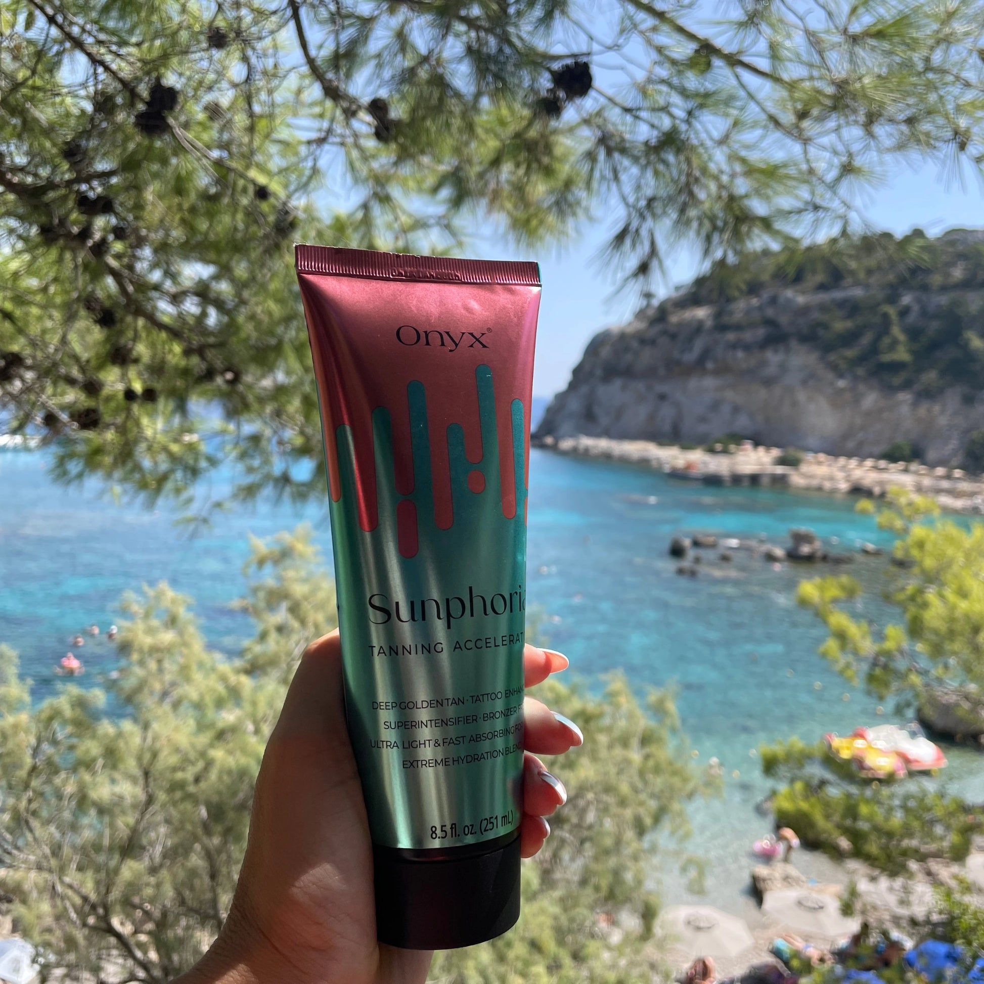 Onyx Sunphoria Tanning Accelerator outdoors near a tropical location.