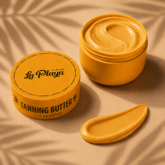 A jar of La Playa by Onyx Tanning Butter shown open with a swirl of golden-yellow cream inside, alongside a dollop of the product on a beige surface with soft leaf shadows.