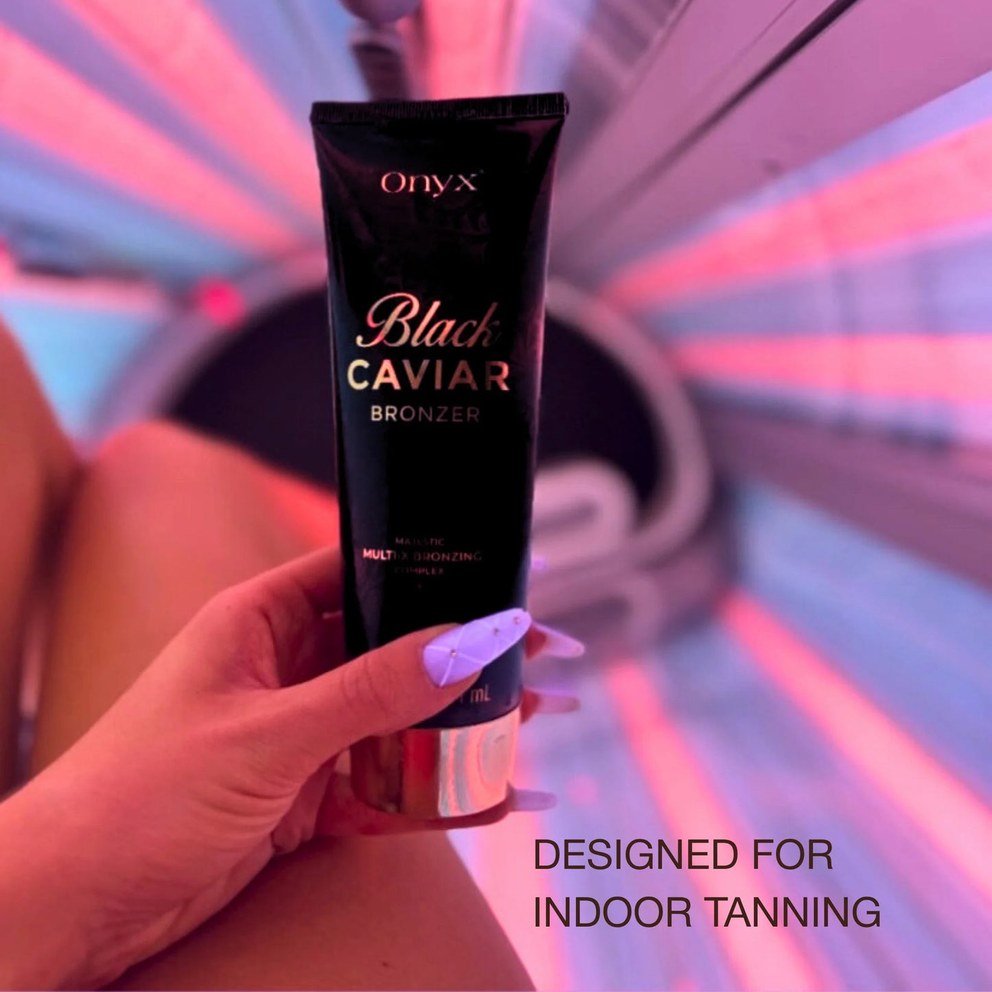 Woman in tanning bed holding Onyx Black Caviar bronzer lotion