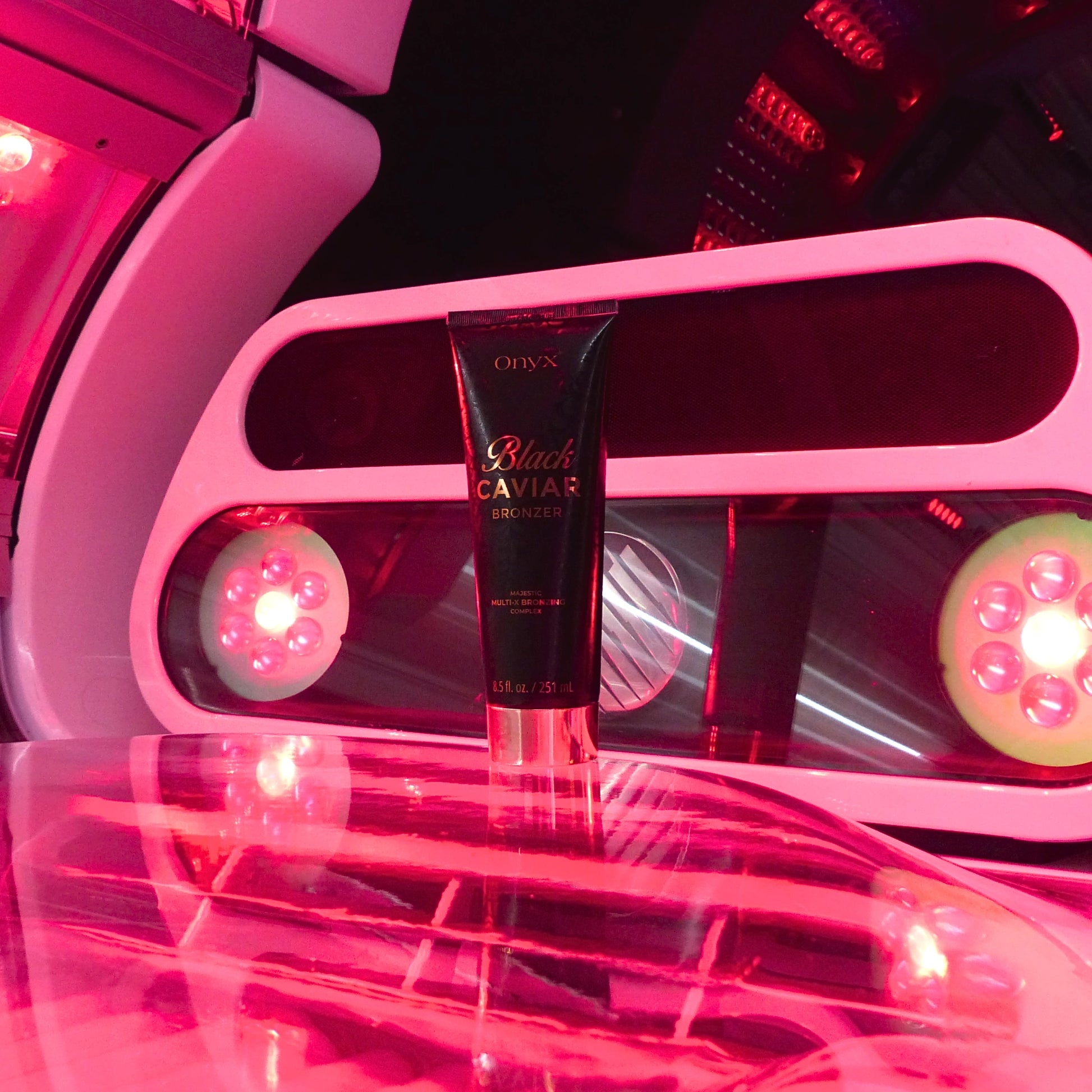 Onyx Black Caviar Bronzing Accelerator positioned inside a UV tanning booth, demonstrating its compatibility with tanning bed sessions.