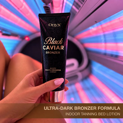 Onyx Black Caviar tanning bronzer held in front of an indoor tanning bed