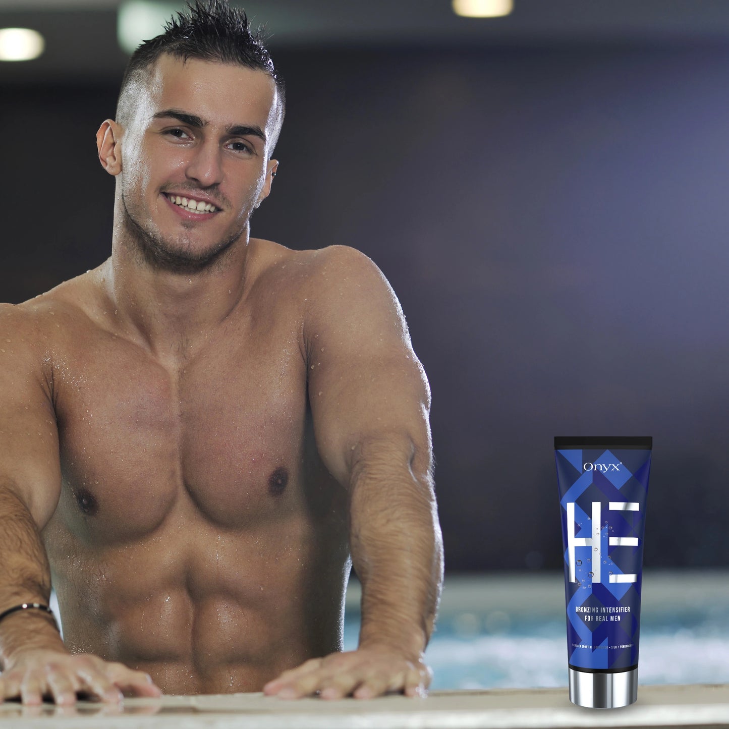 Smiling man in a tanning salon holding Onyx HE Bronzing Lotion – professional tanning accelerator for men.