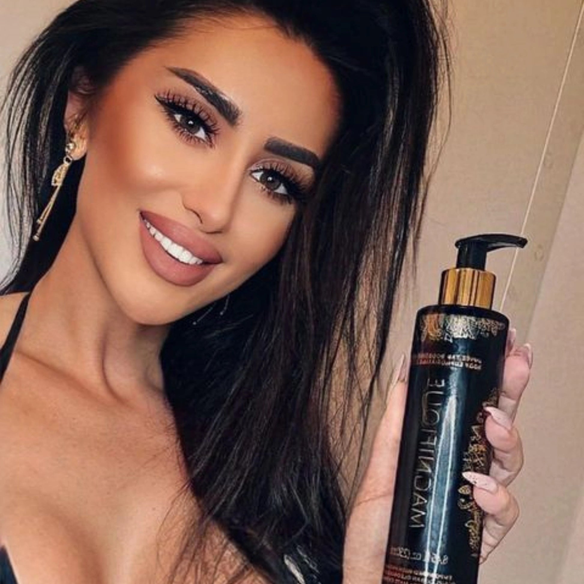 Woman holding Onyx Magnifique Tanning Lotion, highlighting its bronzing and moisturizing properties.