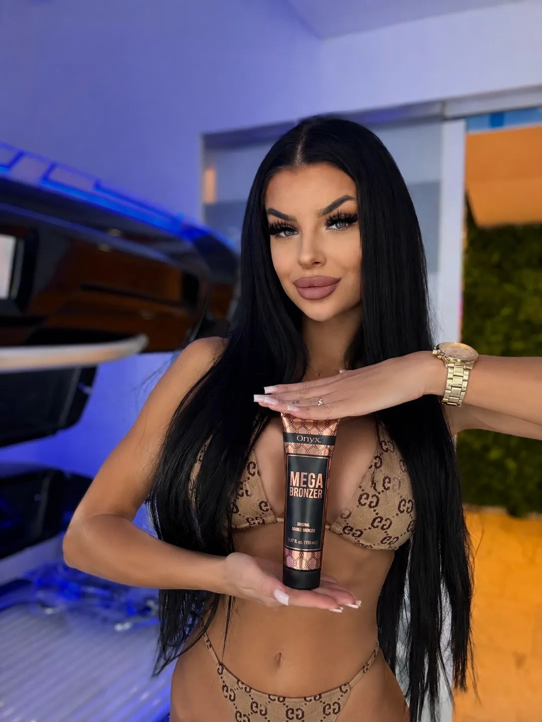 Woman holding Onyx Mega Bronzer in a tanning salon