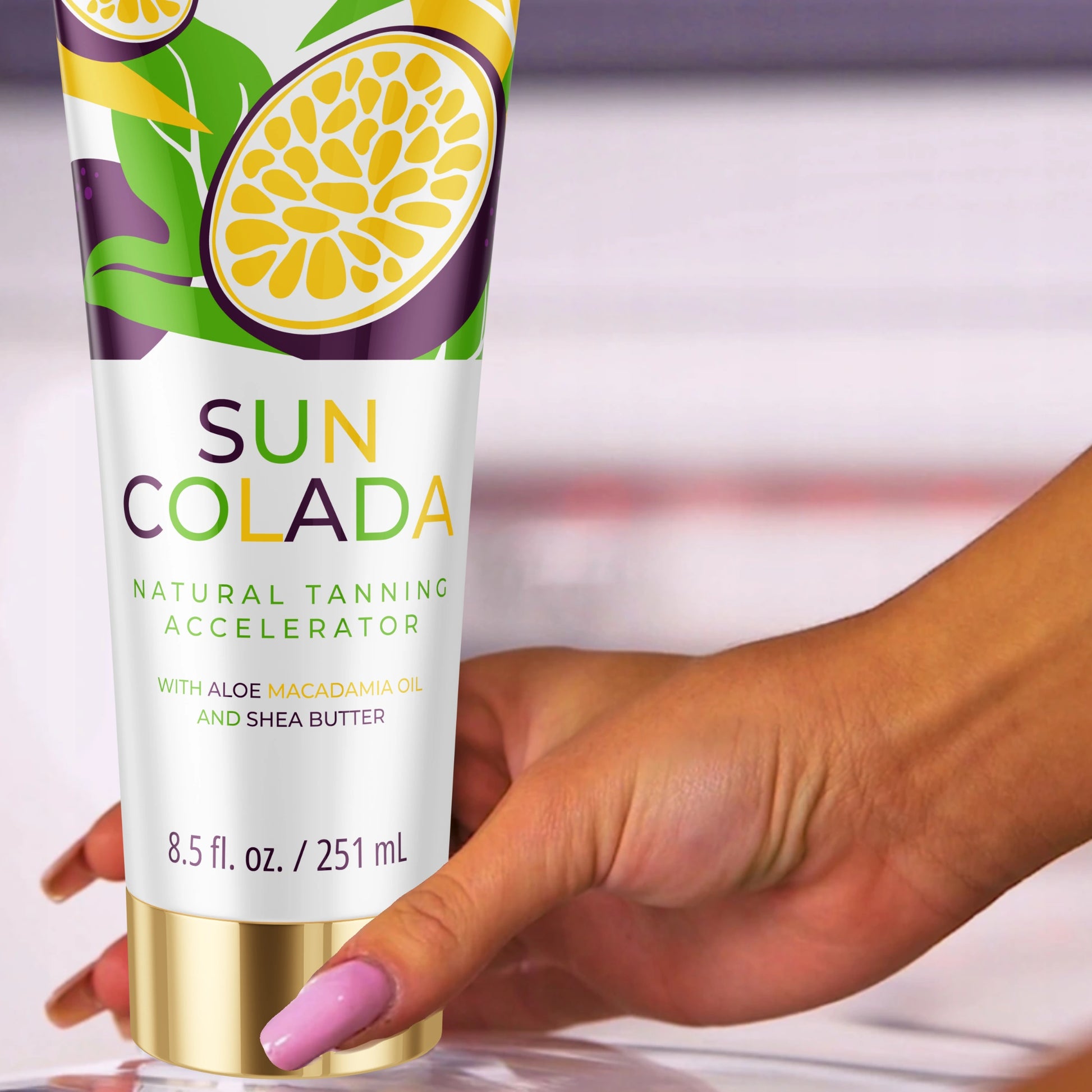 Hand holding Onyx Suncolada tanning lotion with white and gold packaging, infused with shea butter and macadamia oil for ultra moisturizing tan accelerator