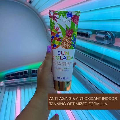 Hand holding Onyx Suncolada Triple Bronzing Juicebomb inside a tanning bed with anti-aging and antioxidant indoor tanning formula text