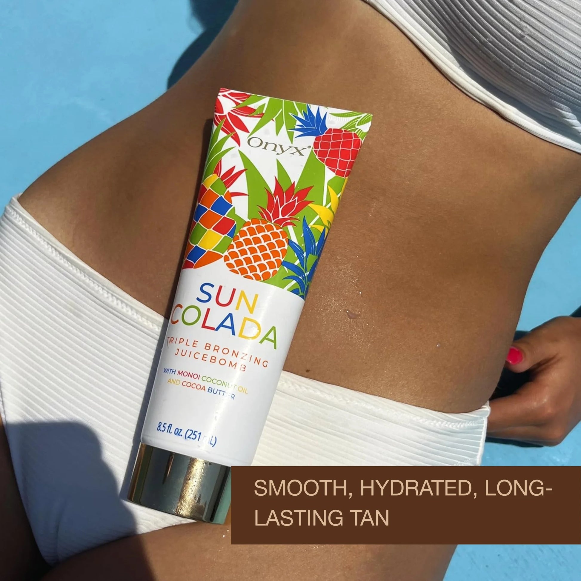 Onyx Suncolada Triple Bronzing Juicebomb tanning lotion placed on a woman’s stomach in a white bikini with smooth, hydrated, long-lasting tan text