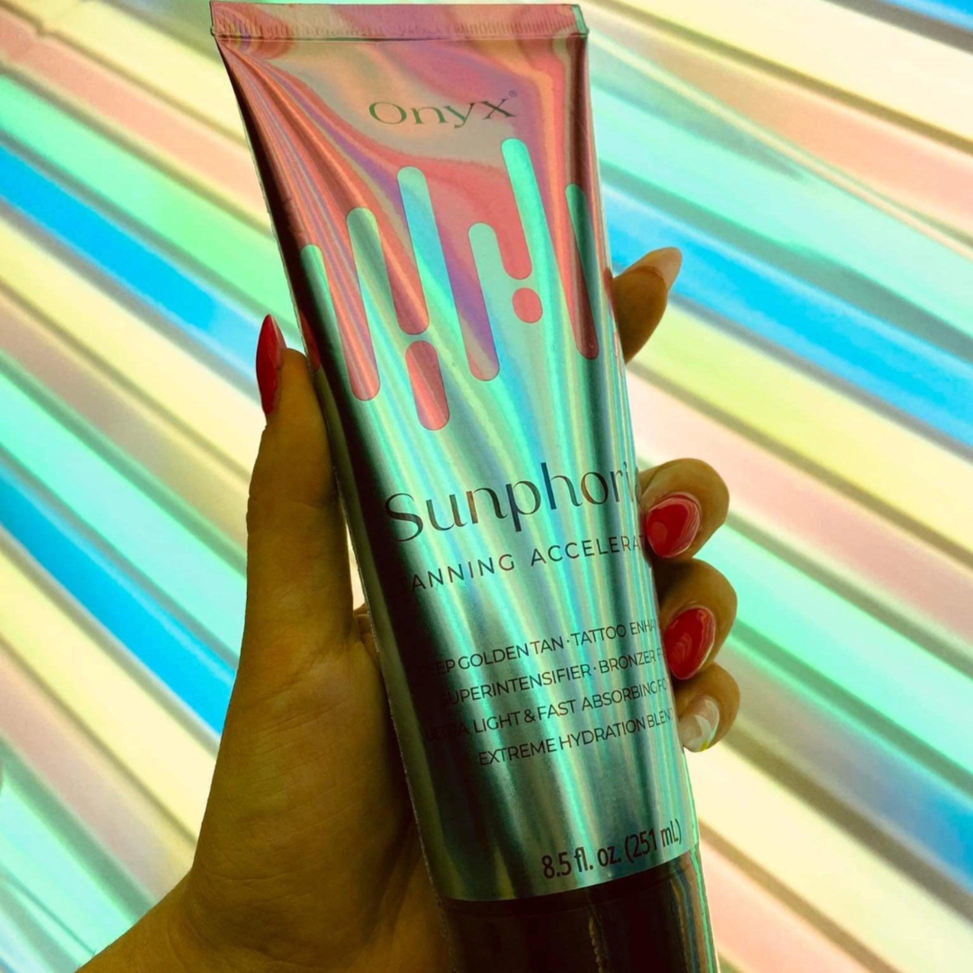 Woman holding Onyx Sunphoria Tanning Accelerator under UV light.