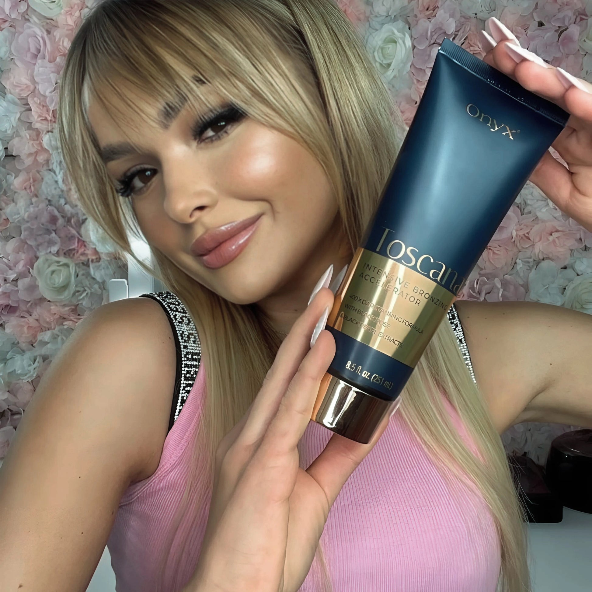 A woman holding Onyx Toscana Bronzing Accelerator, highlighting its premium packaging and tanning benefits.