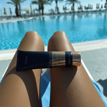 Onyx Toscana Intensive Bronzing Accelerator placed on tanned legs by a swimming pool