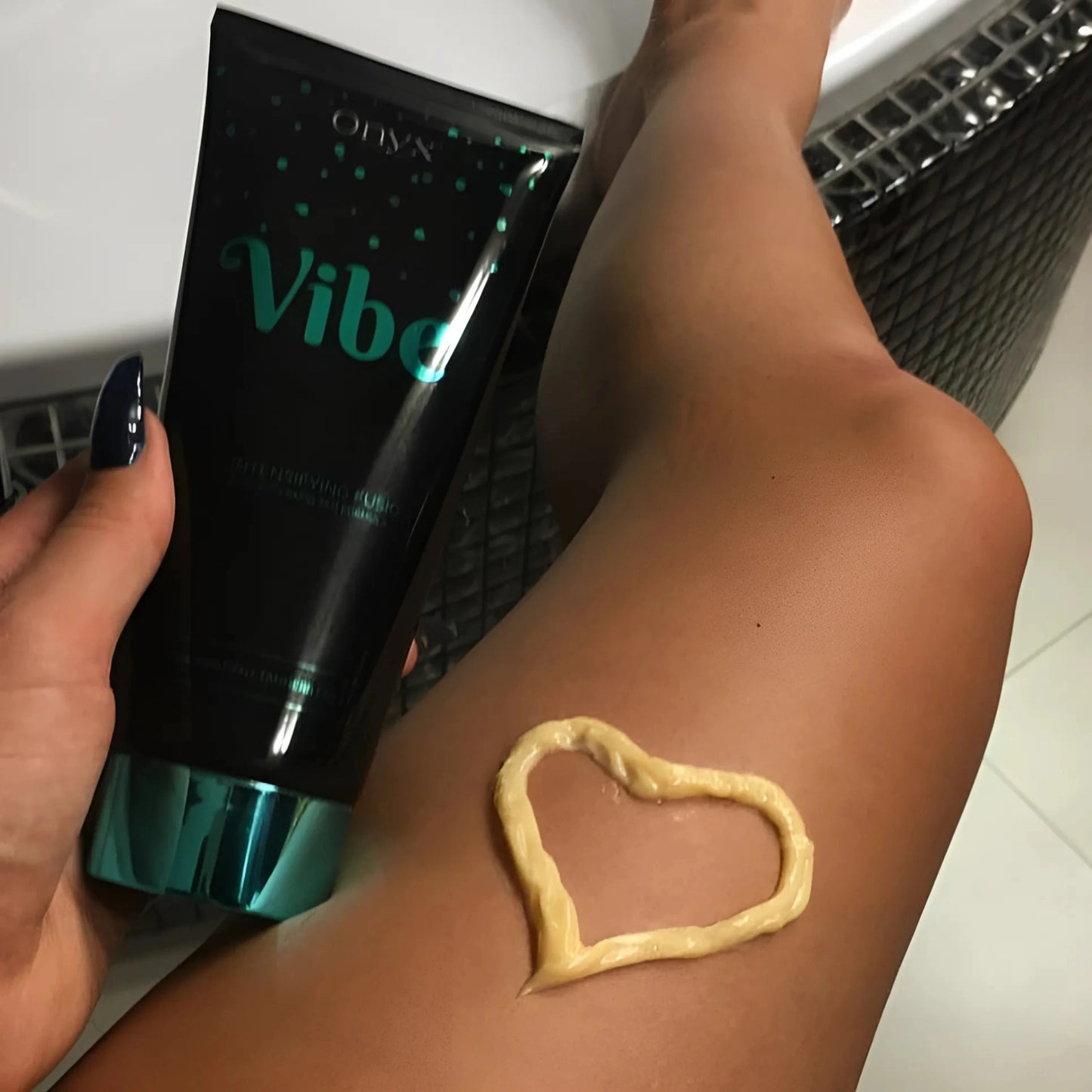 Onyx Vibe Tanning Accelerator applied on tanned skin in a heart shape for smooth, bronzed results.